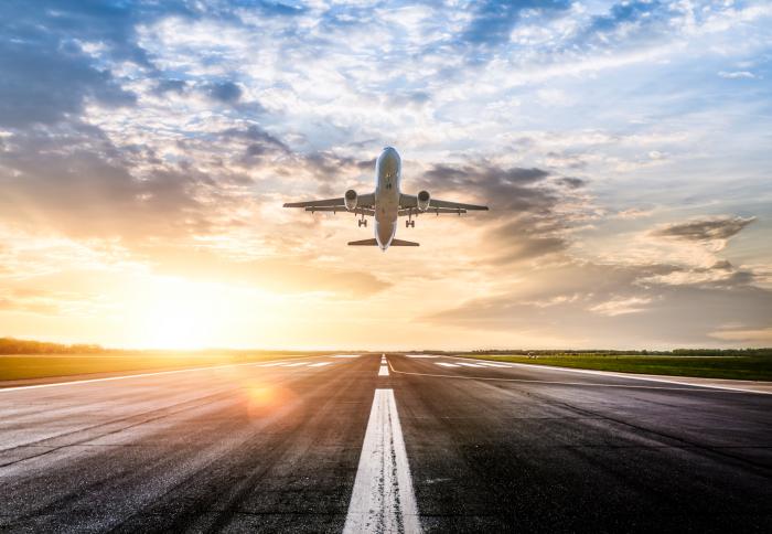 Passenger airplane taking off at sunrise